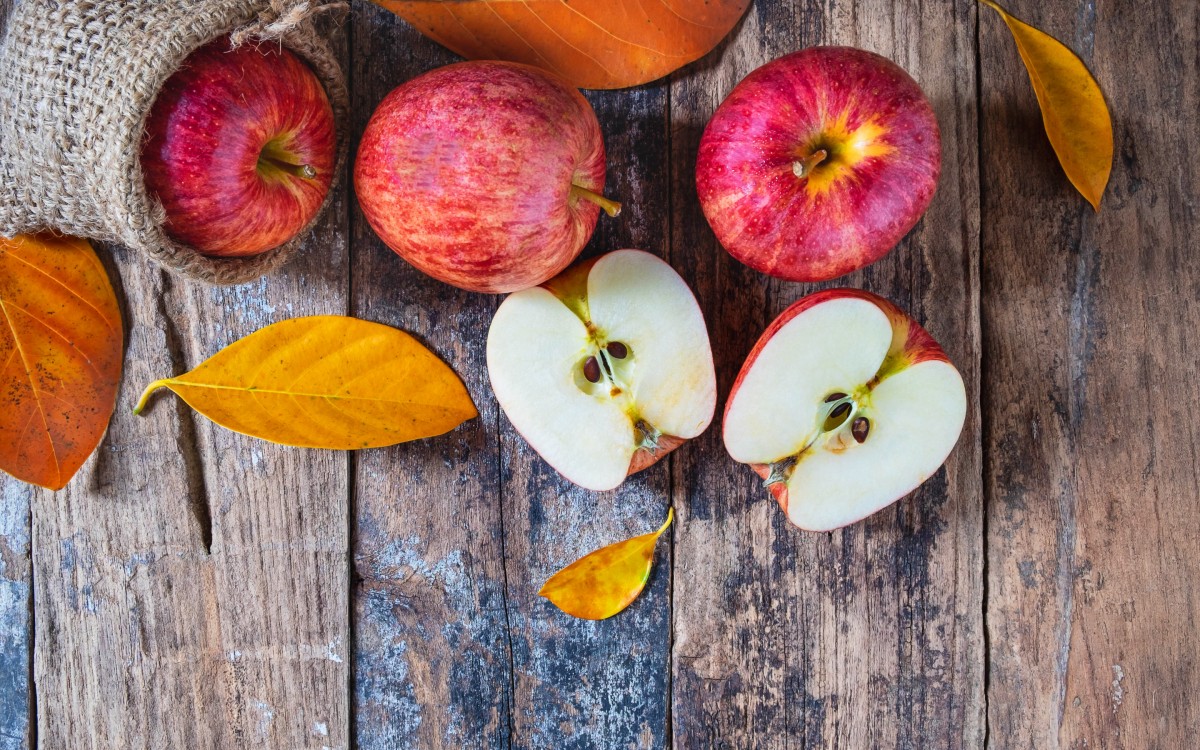 Или кусочек яблока или орешек. Осень яблоки. Лист яблока. Яблоки на деревянном столе. Яблоки в листве.